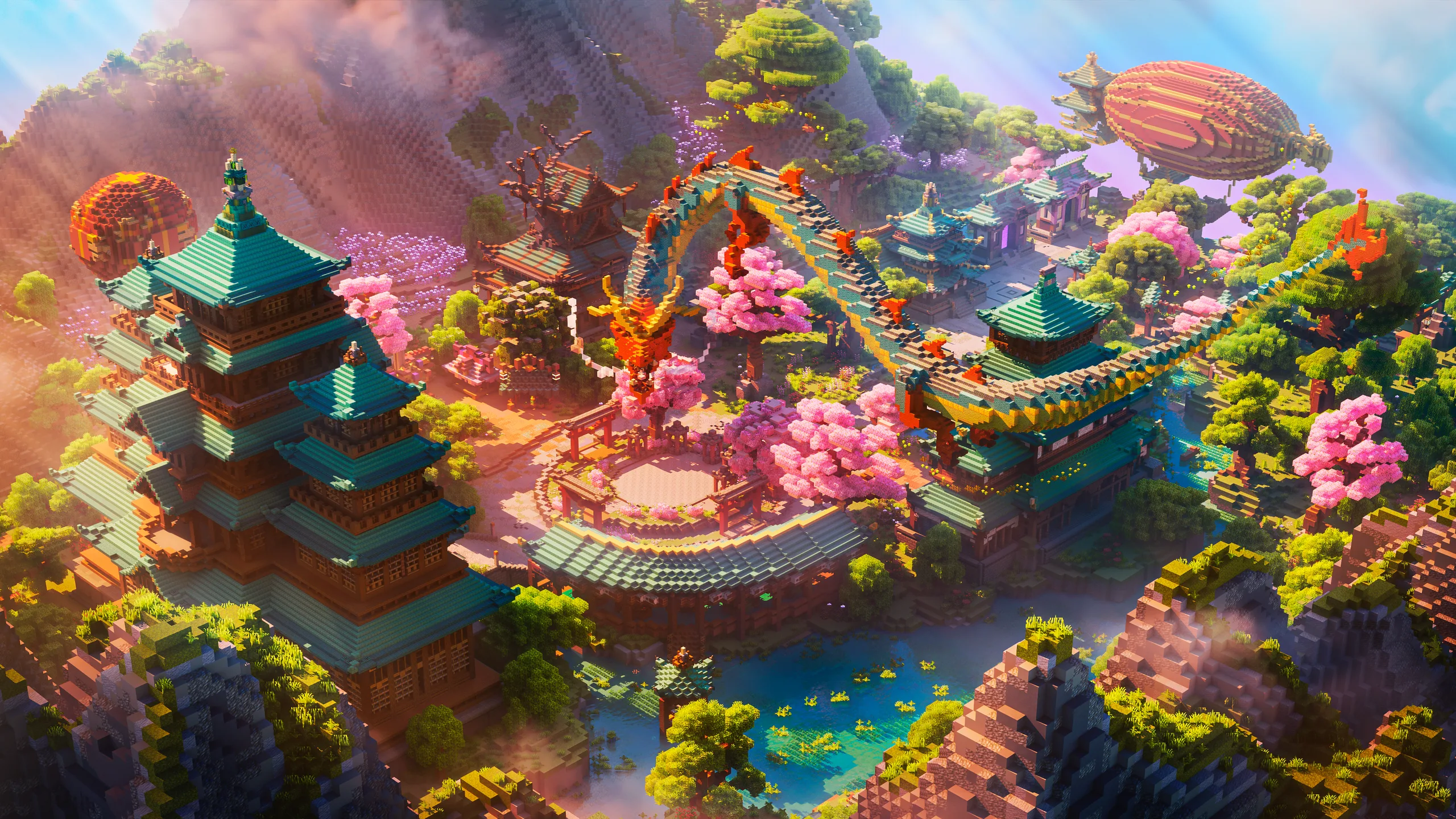 Minecraft landscape with teal-roofed pagodas, a circular stone courtyard, cherry blossom trees, and a turquoise pond amid steep cliffs and lush hills.